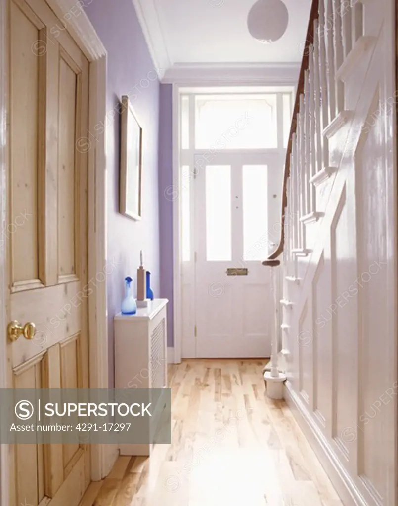 Pine doors and laminate wood flooring in pale mauve hall