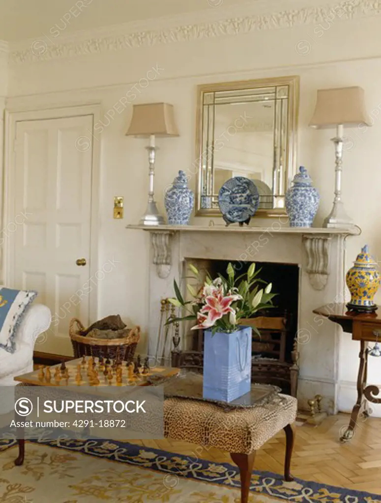 Upholstered stool in front of fireplace in tradtional country living room