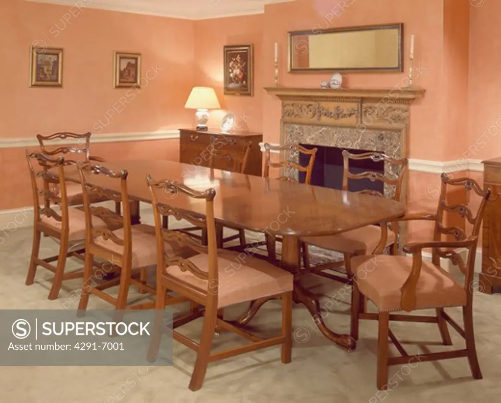 Traditional peach dining room with long antique table and matching chairs