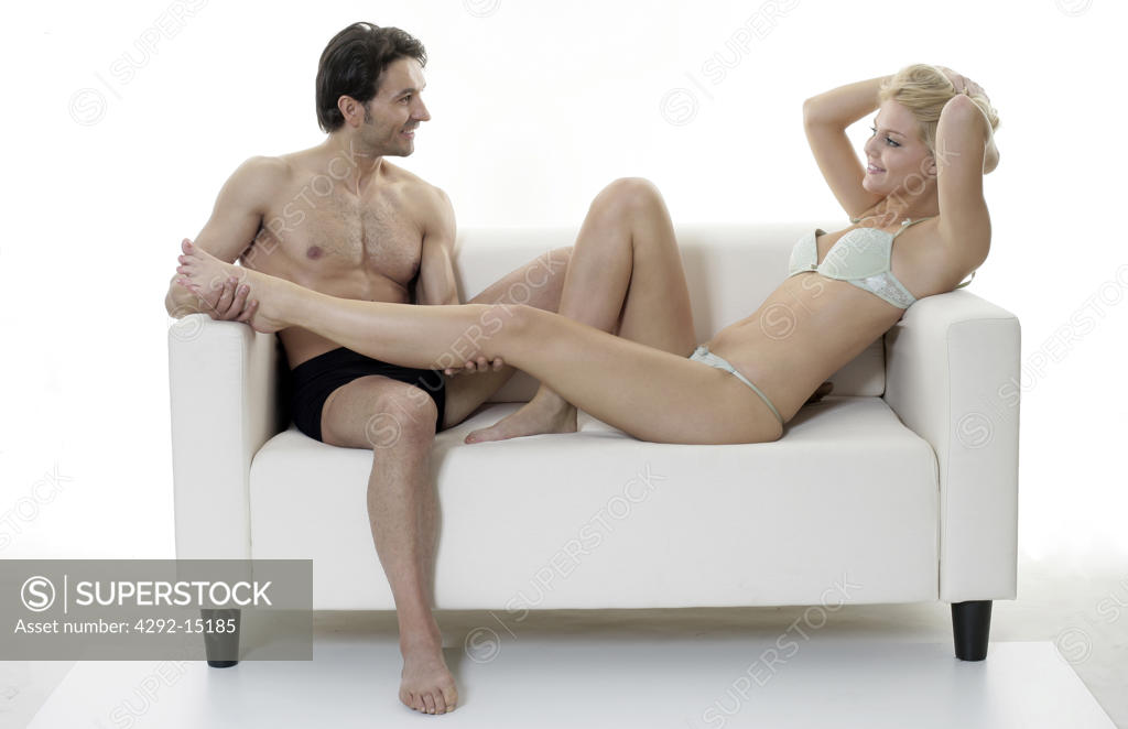 Woman in lace underwear is kneeling on the sofa with her hands up and bent  over Stock Photo by boomeart