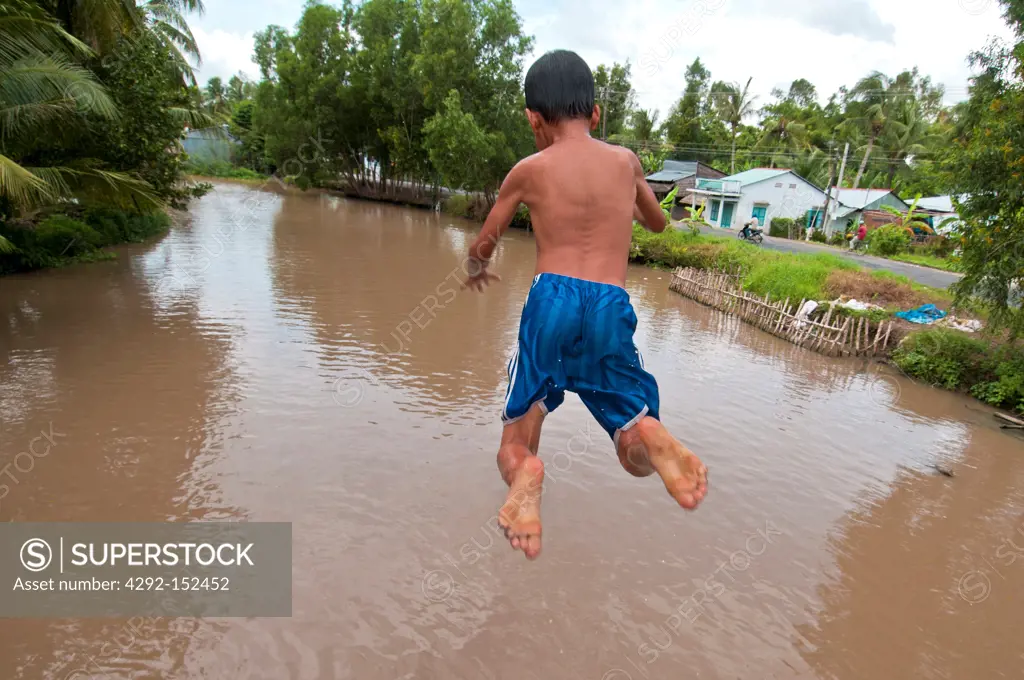 Kid jumping from a bridge, Mekong Delta, Can Tho area, Vietnam