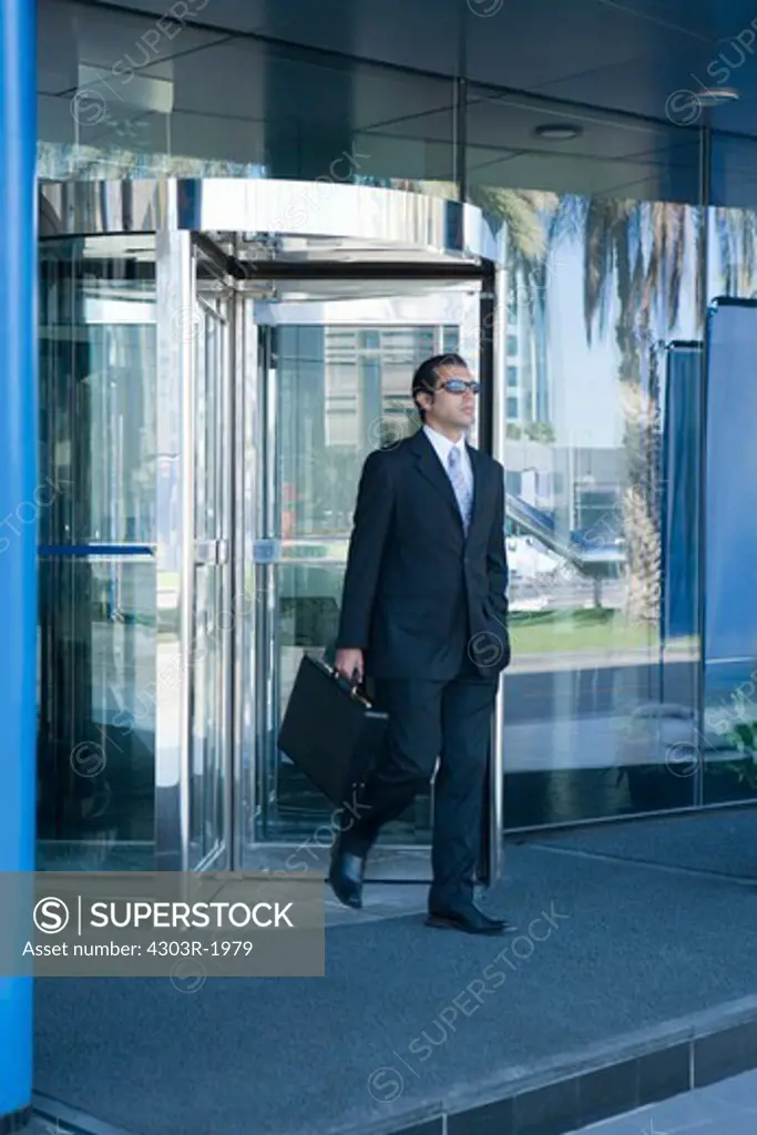 Businessman holding briefcase and walking