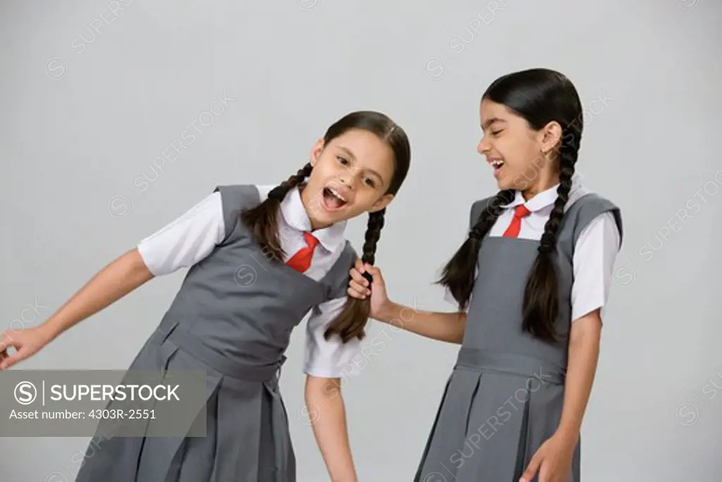 One naughty school girl pulling another girls hair