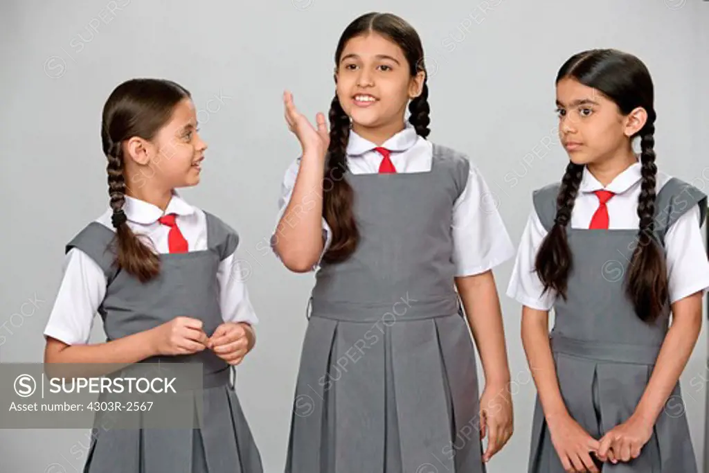 Three girls wearing school uniform talking