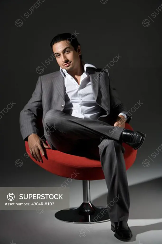 Young man sitting on swivel chair, portrait