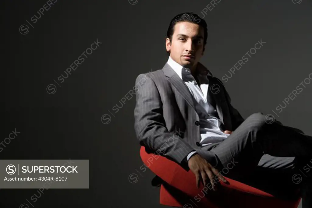 Young man sitting on swivel chair, portrait