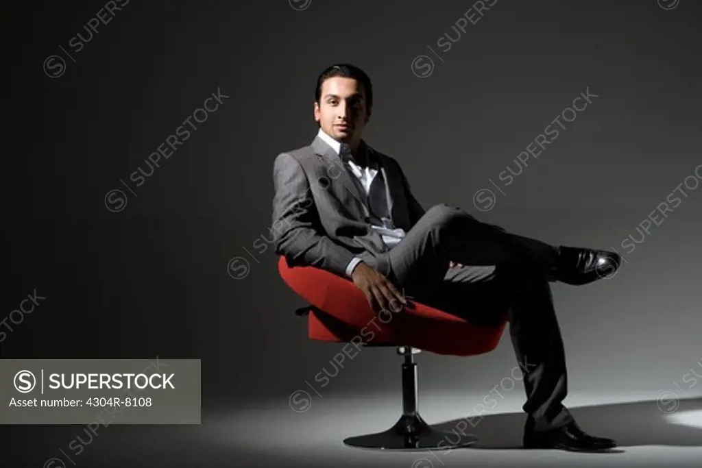 Young man sitting on swivel chair, portrait