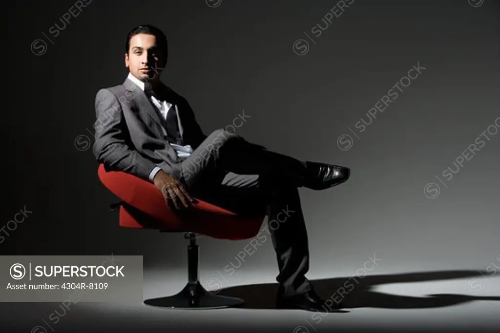 Young man sitting on swivel chair, portrait