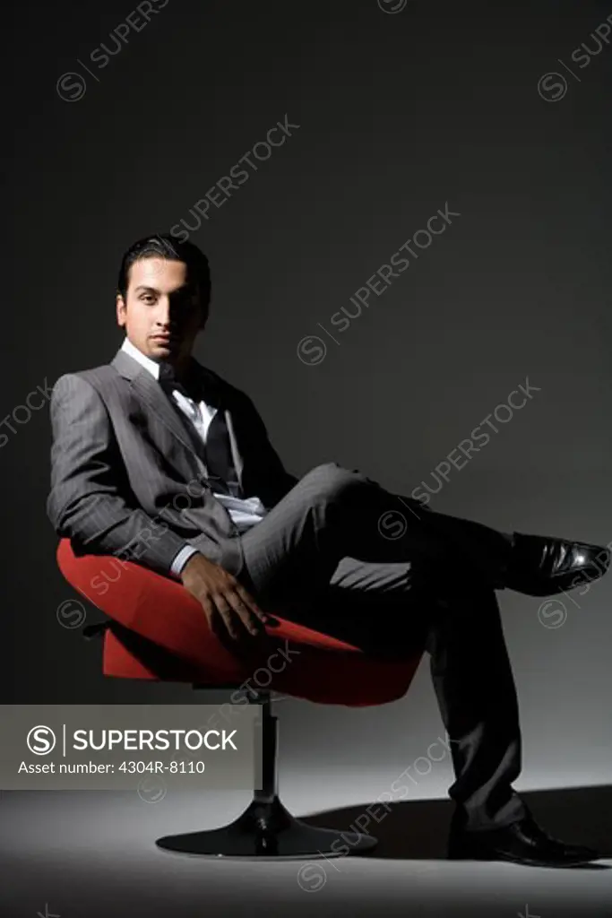 Young man sitting on swivel chair, portrait