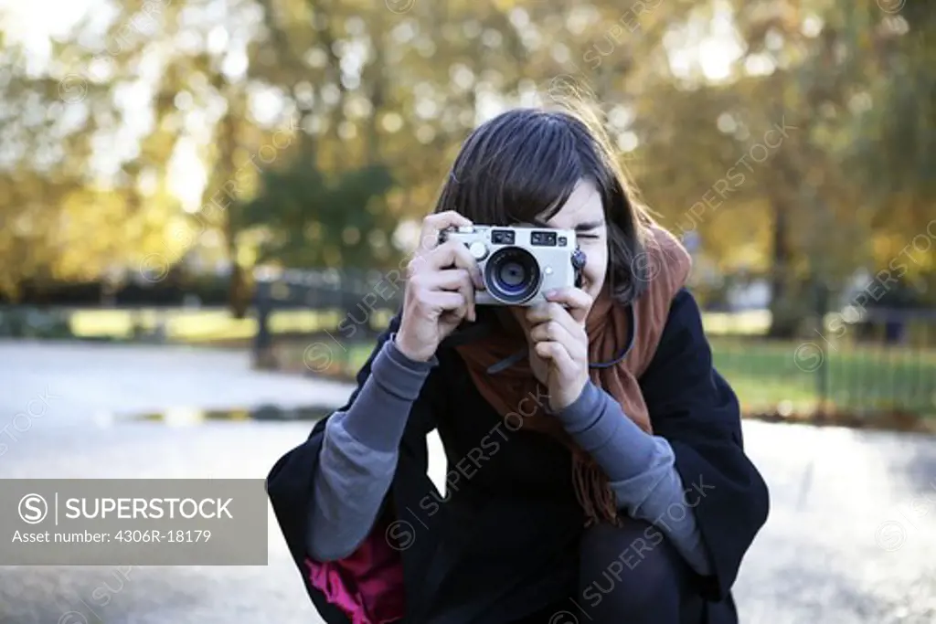 A woman taking a picture, London, Great Britain.