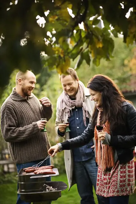 Three friends having a barbeque, Sweden.