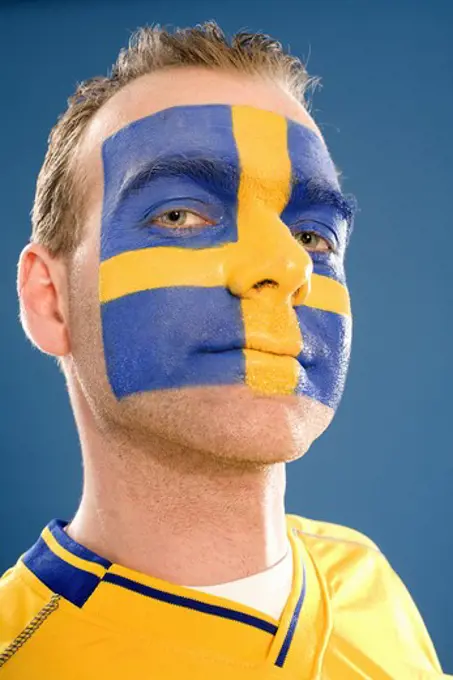 A man with the Swedish flag painted in his face.