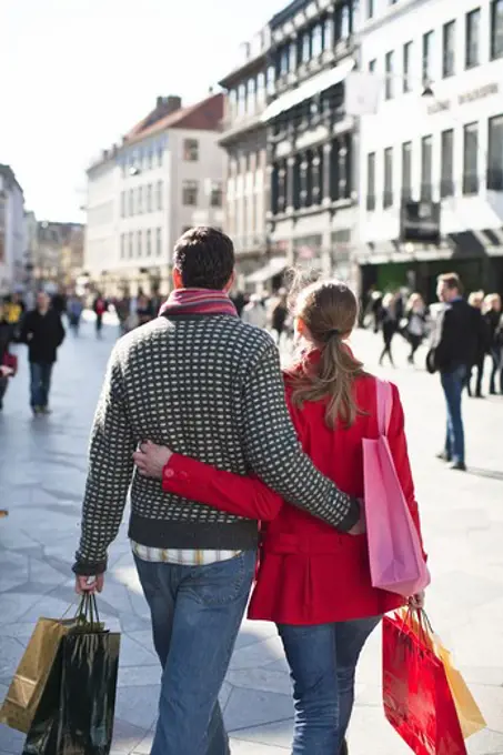 Couple with shopping bags, walking in city