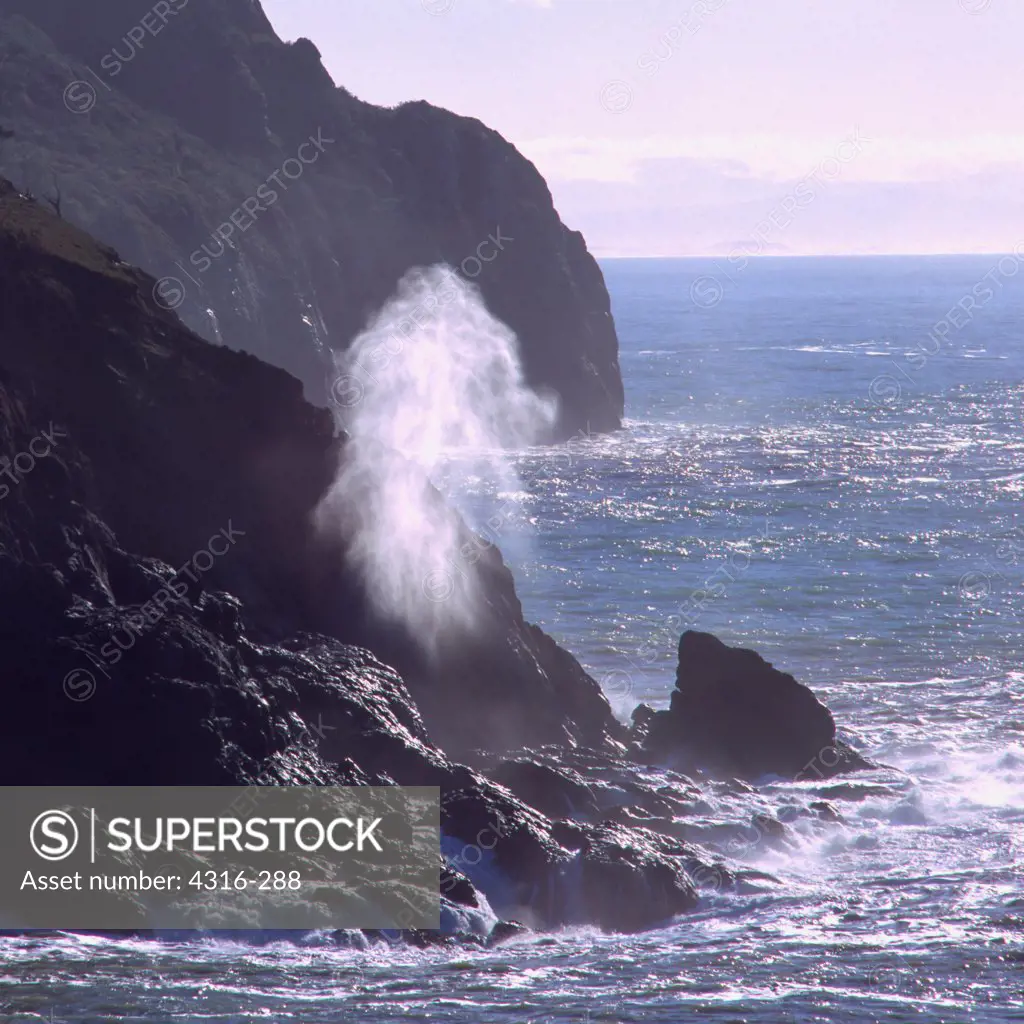 Mist of a Breaking Wave Funneled Through a Vertical Fissure