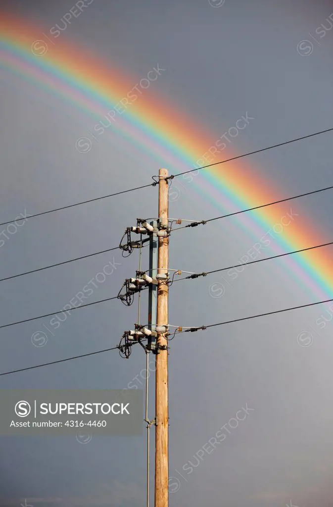 Rainbow frames powerline pole SuperStock