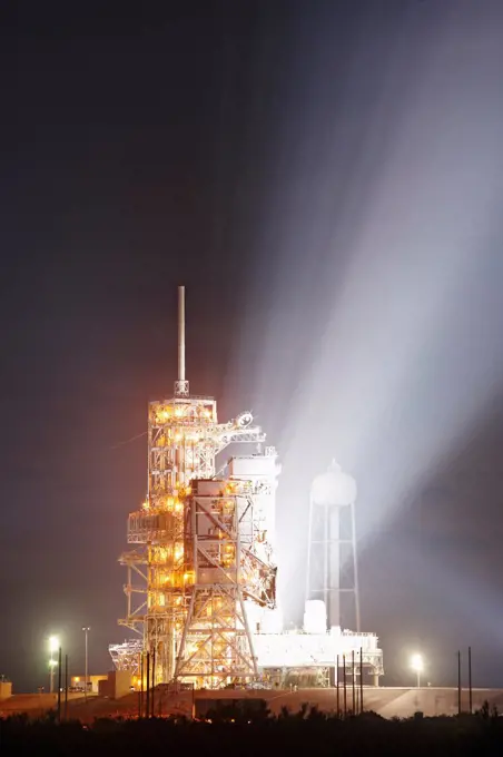 Powerful xenon floodlights illuminate the early morning sky from the launch tower at Pad 39A, Kennedy Space Center, Florida, after the launch of Space Shuttle Endeavour on STS-130.