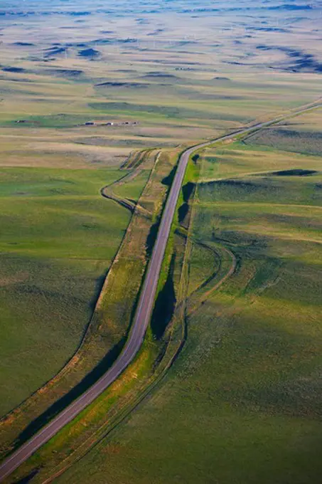 An aerial view of a paved road through green plains, in eastern Colorado.