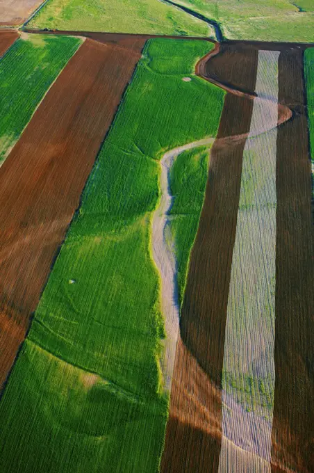 An aerial view of farm land and a dry stream bed, in eastern Colorado.