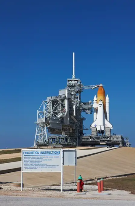 Space Shuttle Endeavour poised to launch on Space Transportation System 130 with the Rotating Service Structure rolled back and sign with evacuation instructions in foreground sitting on Pad 39A at Launch Complex 39, NASA Kennedy Space Center, Merritt Island, Florida, USA