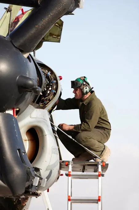 United States Marine Corps aircraft maintenance specialist working on an engine housed inside an engine nacelle of an MV-22 Osprey, Camp Bastion, Helmand Province, Afghanistan