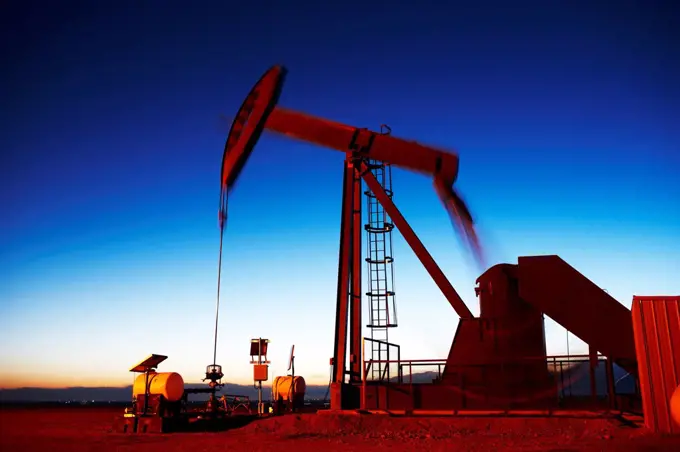 Oil well pumpjack at dusk, eastern plains of Colorado, USA