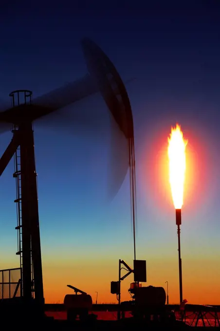 USA, Colorado, Oil well pumpjack (pump jack) and gas flare (flare stack), Oil well developed with hydraulic fracturing, also known as hydrofracking or fracking