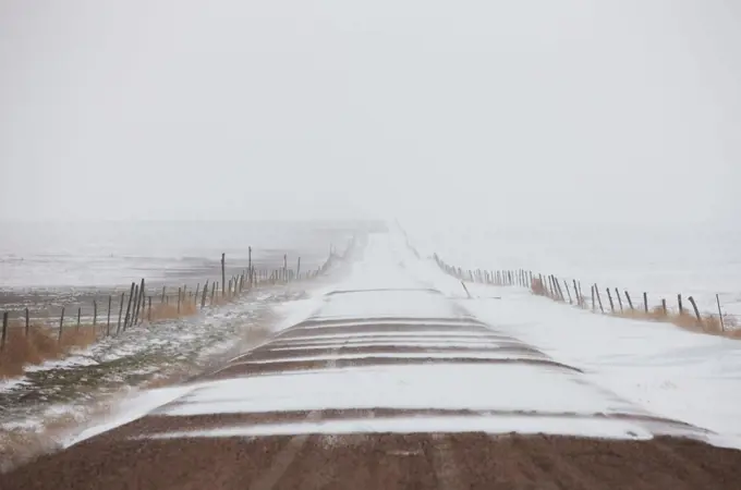 USA, Colorado, Eastern Plains of Colorado, Dirt road partially covered in wind-driven snow during blizzard