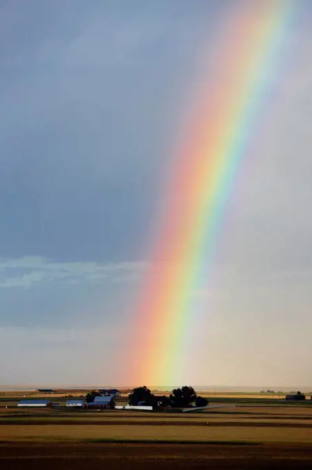 Intense rainbow over ranch in the wake of an intense thunderstorm, Colorado