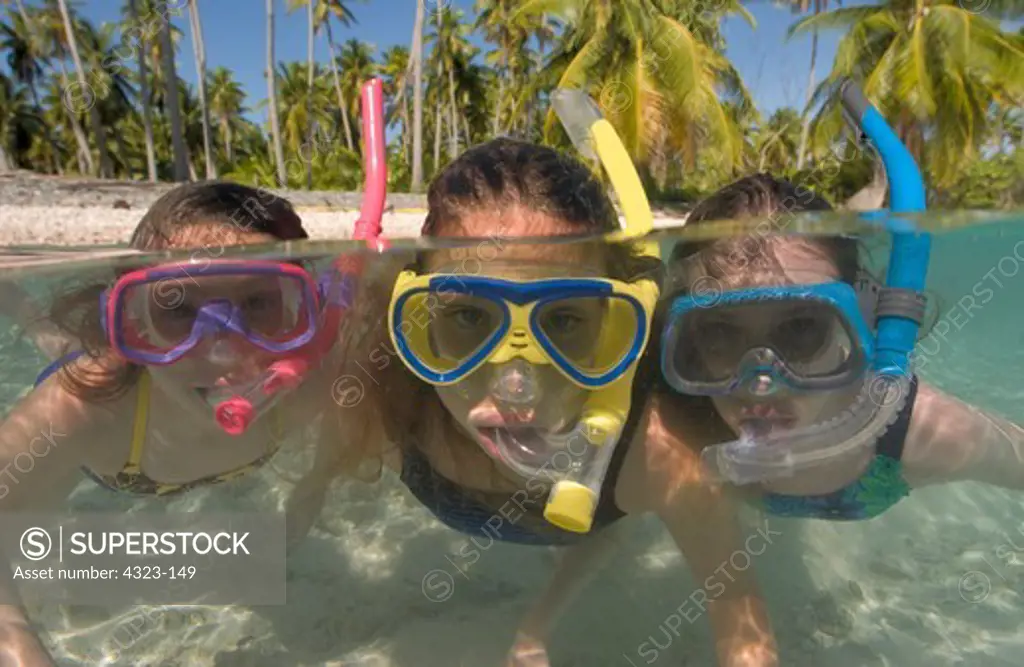 Split View of Three Girls Snorkeling with Water and Palm Trees