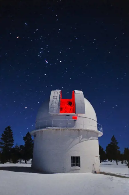 The 42" telescope glows softly red in this time exposure of the dome illuminated by a partial moon. Just above the dome the constellation Orion is rising into the winter sky. The 42" telescope is one of several that Lowell Observatory uses on Anderson Mesa, located just south of Flagstaff, Arizona.