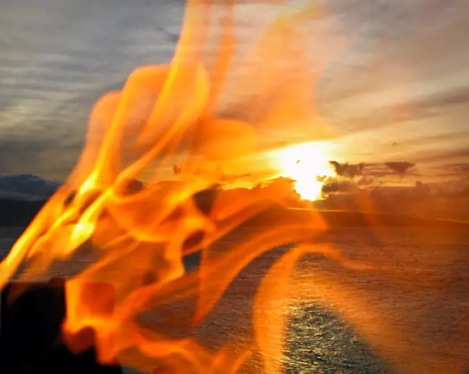 This is part of the sunset torch lighting ceremony at Black Rock in Maui. Black rock is in the town of Lahaina. In the background is the island of Lana'i.