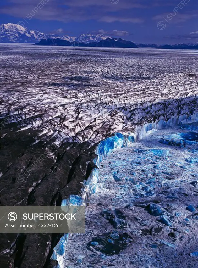 Aerial view of peidmont lobe of the Bering Glacier calving deep blue water-saturated icebergs into Lake Vitus, Alaska.