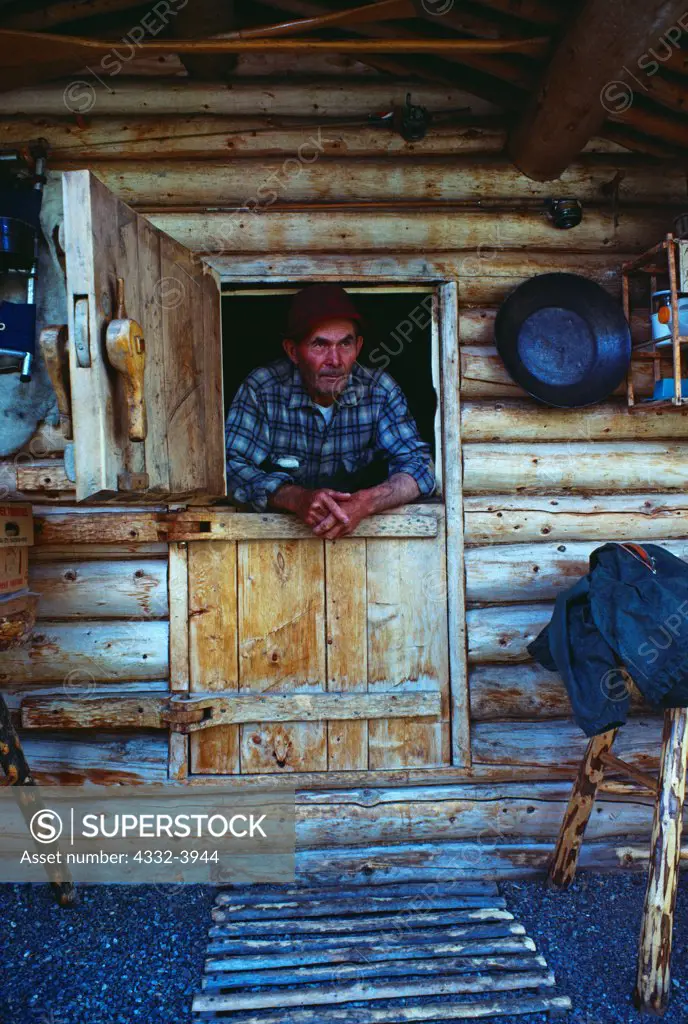 Dick Proenneke in dutch doors he handcrafted with spruce root hinges, Upper Twin Lake, Lake Clark National Park, Alaska.