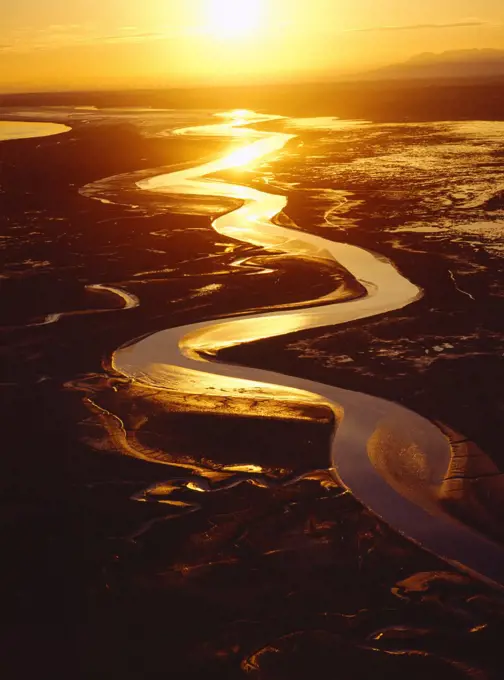 Aerial photo of sun setting over mudflats where the Matanuska and Knik Rivers drain into the Knik Arm of Cook Inlet, Alaska.