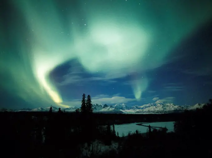 Beautiful display of northern lights over the Alaska Range including Mount McKinley or Denali with the Chulitna River in the foreground, Denali State Park, Alaska.