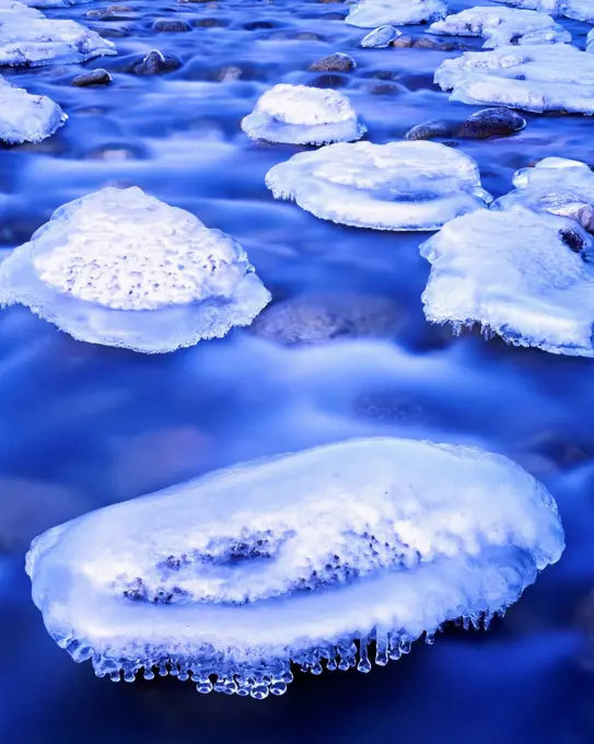 Ice coating boulders in the bed of Granite Creek as it flows from the Talkeetna Mountains, Alaska.