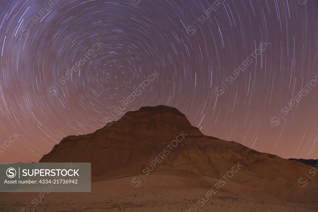 Star Trails with the North Star and the Manly Beacon in the Alluvial Fans in the Bad Lands of Death Valley National Park in California