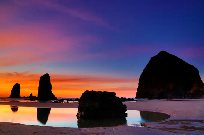 USA, Oregon, Cannon Beach, View of sunset afterglow over Haystack Rock