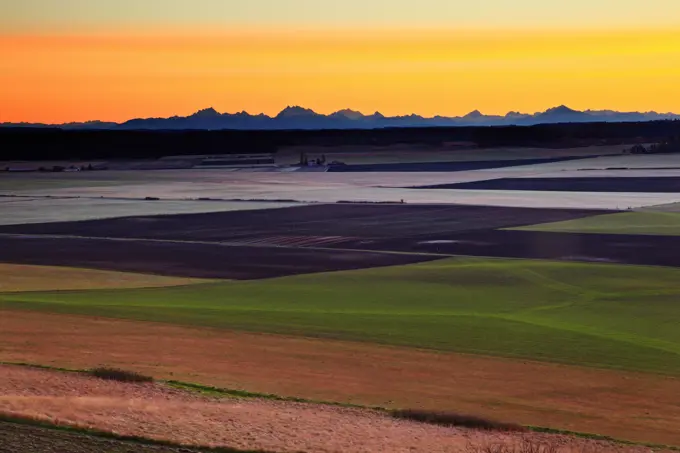 Sunrise from Ebey's Prairie, Whidbey Island, Washington, with the line of the Cascades on the horizon.