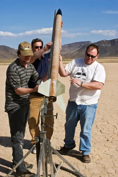 A group of men sets up a rocket for launching at Springfest '06 on Jean Dry Lake in Nevada.