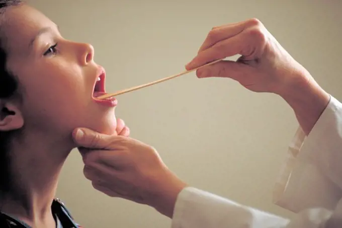 Pediatrician Examines Young Girl's Throat