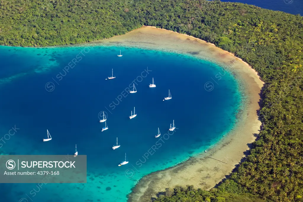 Boats anchored in a cove of one of the islands of Tonga seen from the air, Kingdom of Tonga, South Pacific Ocean.