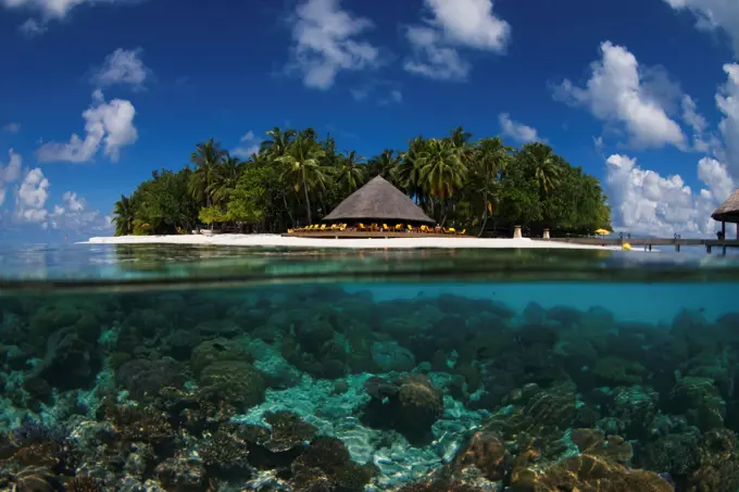 Split shot of coral reef and gazebo on island, Angsana Ihuru, North Male Atoll, The Maldives.