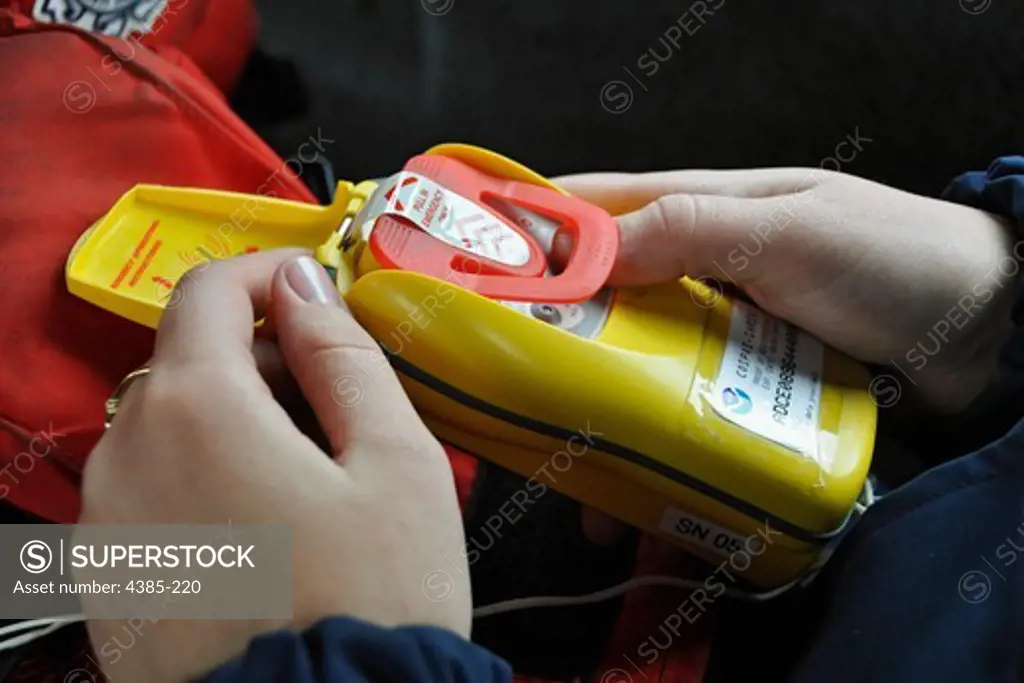 Coast Guard Seaman Samantha Randall, 20, of Coast Guard Station King's Point in King's Point, New York, displays a personal Emergency Position Indicating Radio Beacon (EPIRB) required to be carried by U.S. Coast Guardsmen who are underway. The Coast Guard strongly urges mariners to be prepared in case of emergencies and to bring survival equipment such as signalling and sound devices, a personal EPIRB, cell phone, radio and lifejackets while underway to increase chances of survival in the event 