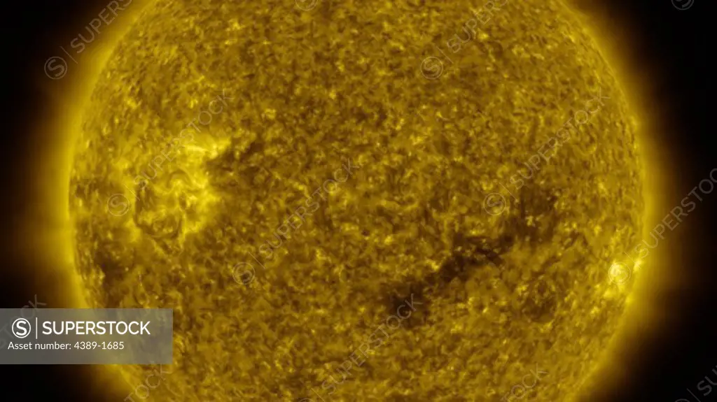 The dark coronal hole in the Sun's lower region is a 'open' magnetic area through which the solar wind follows, here in between to active areas, and seen in this view from Solar Terrestrial Relations Observatory (STEREO)'s  284 Angstrom instrument.