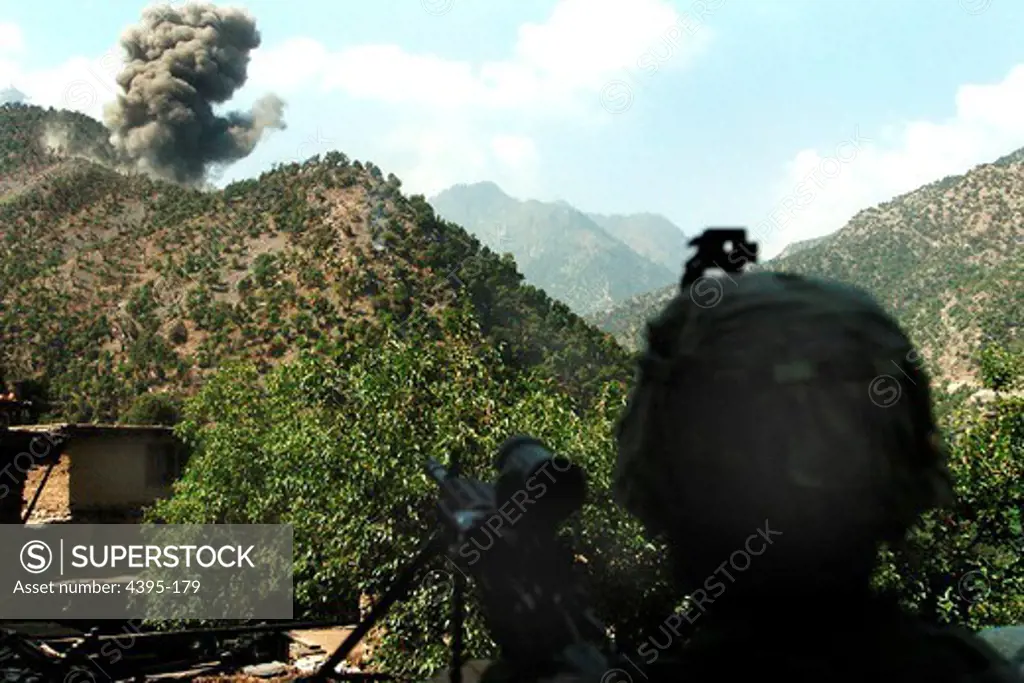 KUNAR PROVINCE, Afghanistan - A U.S. Army Soldier watches as U.S. Air Force F-15 Fighter Jets destroy insurgent positions with a bomb, after a 20 minute gun battle in Kunar province Afghanistans Korengal Valley, Aug. 13.