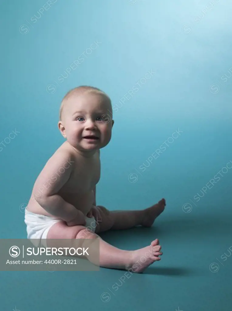 Portrait of a baby against turquoise background.