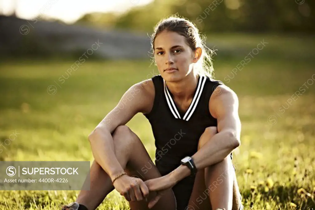 Young female runner relaxing, Sweden.