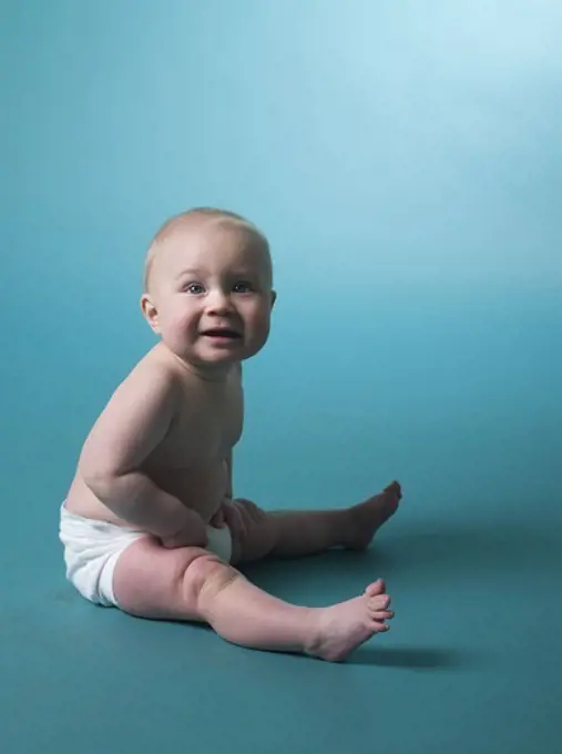 Portrait of a baby against turquoise background.