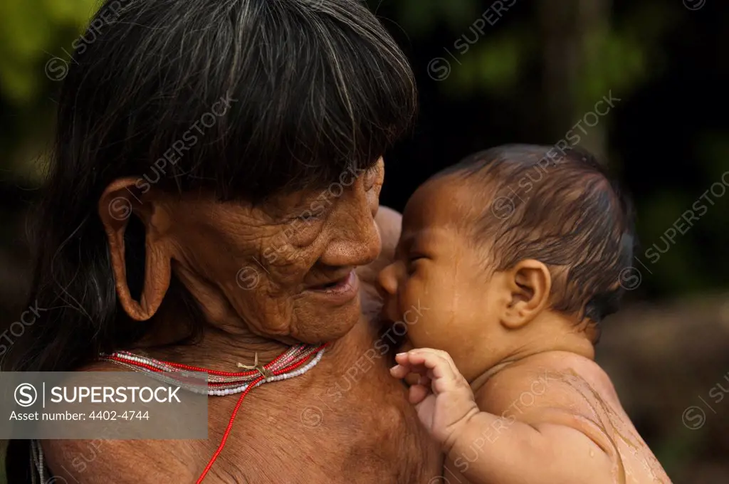 Huaorani Indian woman holding baby. Gabaro Community, Yasuni National Park, Amazon rainforest, Ecuador, South America.